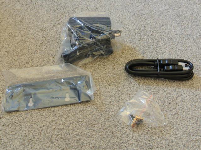 3 plastic bags containing a power supply, a vesa bracket and some screws. There&rsquo;s also a tightly-wound HDMI cable with plastic protective covers over both ends